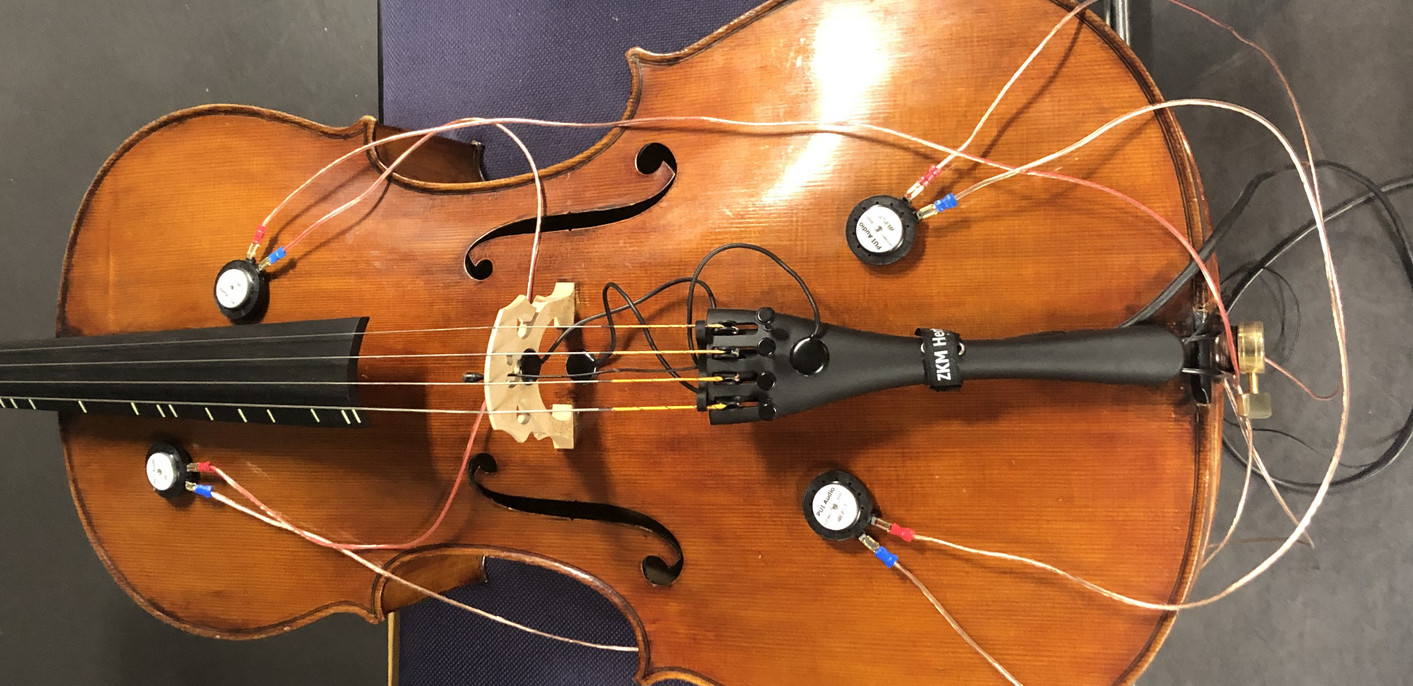 En cello med fire transducere monteret på forsiden af instrumentet (studie)